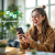 Young woman laughing with smartphone in hand; next to her 